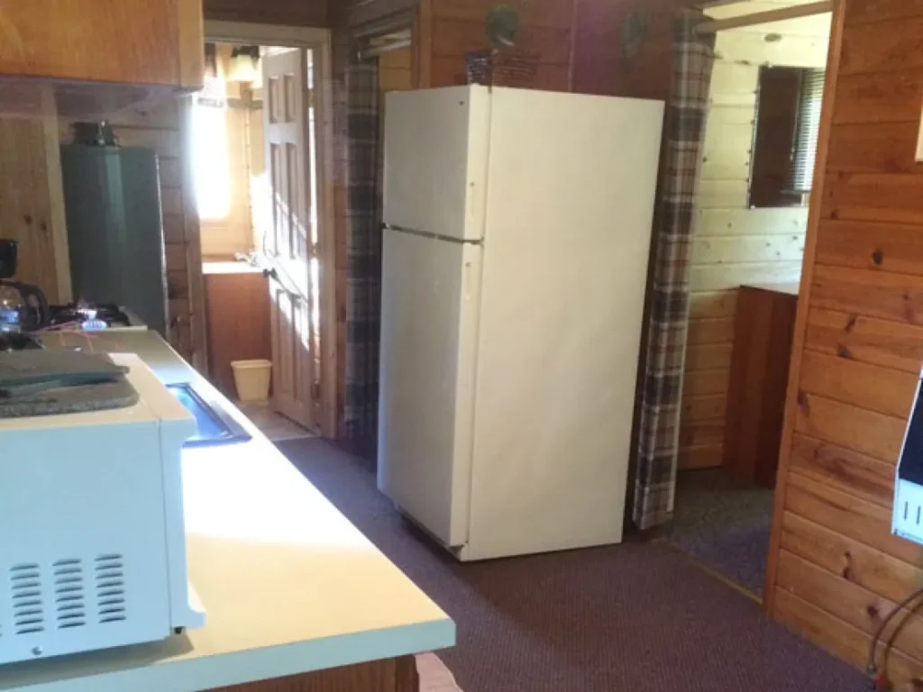 An inside look at the kitchen of the Alder cabin. IT has a microwave, stove, and refrigerator.