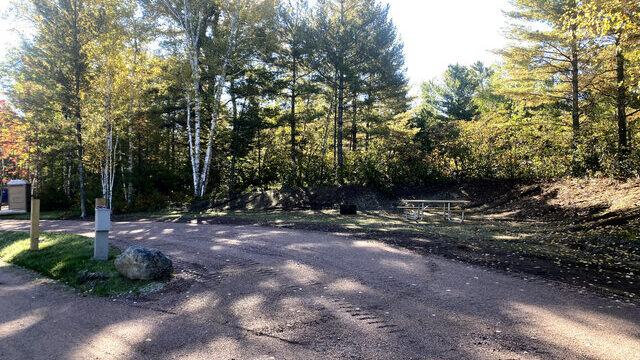 A picture of one of the RV sites at the Babbitt Campground and RV Park. It has full hookups and a table.