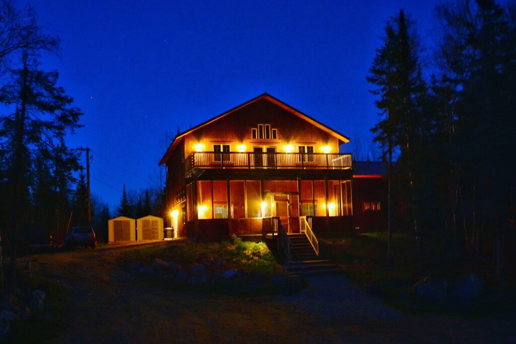 A night view of the outside of a cabin at the Boundary Water Grouse Lodge.