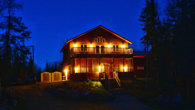 A night view of the outside of a cabin at the Boundary Water Grouse Lodge.