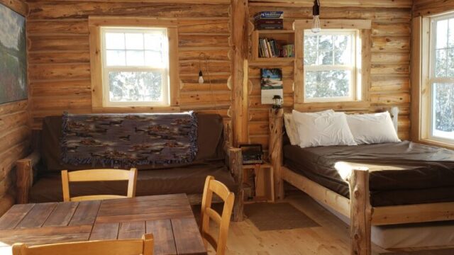 An inside view of the Bucksnort cabin. It has a couch, bed, and table.