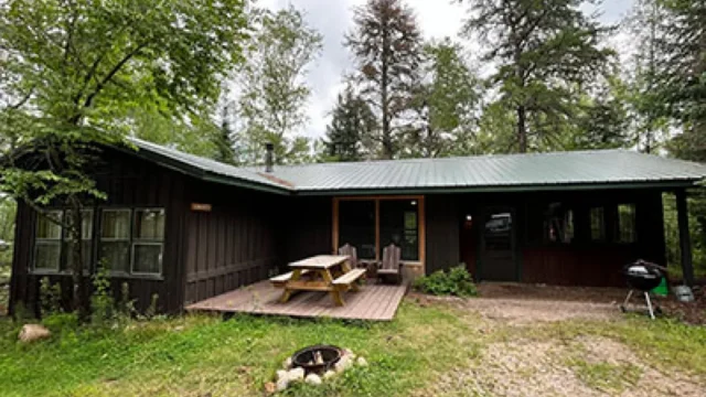 An outside view of the Castillo cabin. It has a picnic , and charcoal grill.