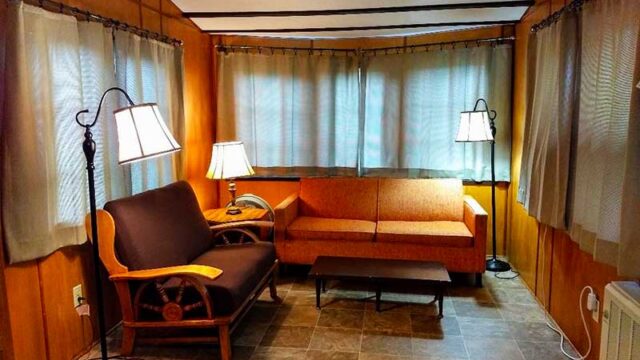The living room of one of the cabins at Canoe Country Cabins. It has two couches and an end table.