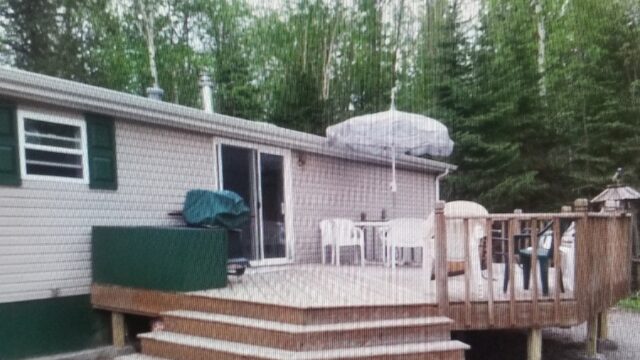 The outside of one of the cabins at Echo Shore Resort. It shows the outdoor patio with table and chairs for lounging.