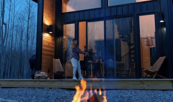 An outside view of the cabin with a small campfire.