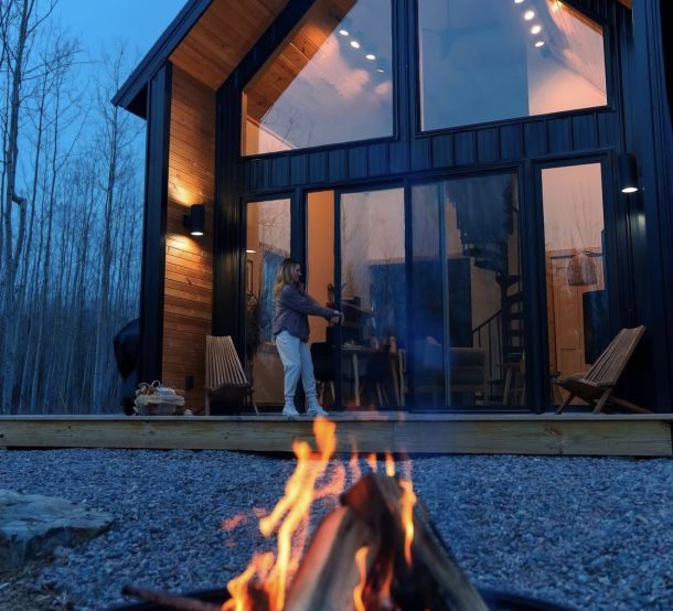 An outside view of the cabin with a small campfire.