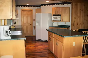 The kitchen of one of the cabins at La Tourell's. It has a kitchen island, refrigerator, oven, stove, and coffee pot.