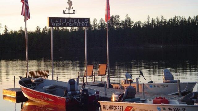 A picture of one of the docks at LaTourell's Resort. There are three boats in water.