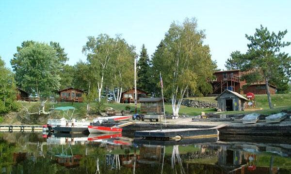 A view of the lake with boats at Packsack Log Cabins.