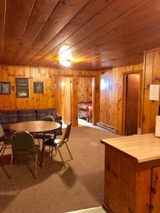 An inside view of one of the cabins at Snowbank Lodge. It has a circle table, and couch.