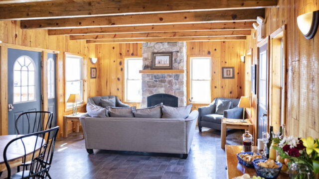 The living room of the Stay Inn Ely with couches and a brick fireplace.