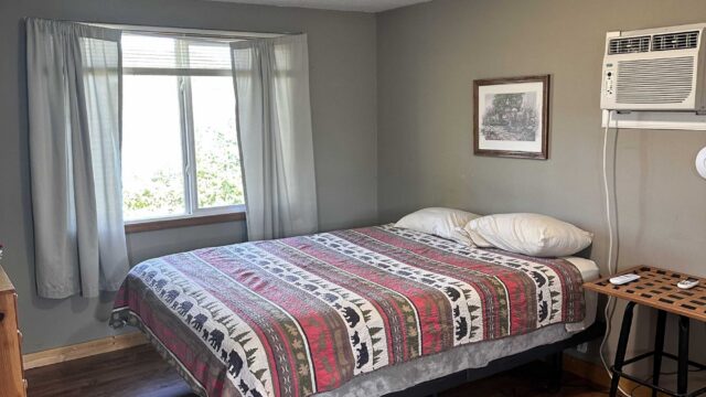 The bedroom of the one bedroom cabin at Veterans on the Lake Resort. It has a queen bed.