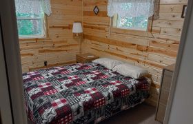 One of two bedroom of a two bedroom cabin at Veterans on the Lake Resort. It has a queen bed.