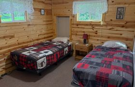 The second of two bedrooms of a two bedroom cabin at Veterans on the Lake Resort. It has two twin beds.