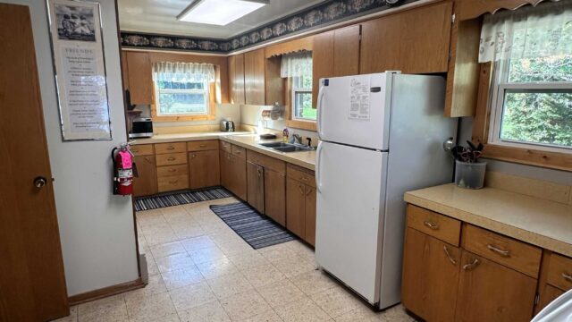 The kitchen of the five bedroom cabin at Veterans on the Lake Resort. It has a refrigerator, stove and oven.